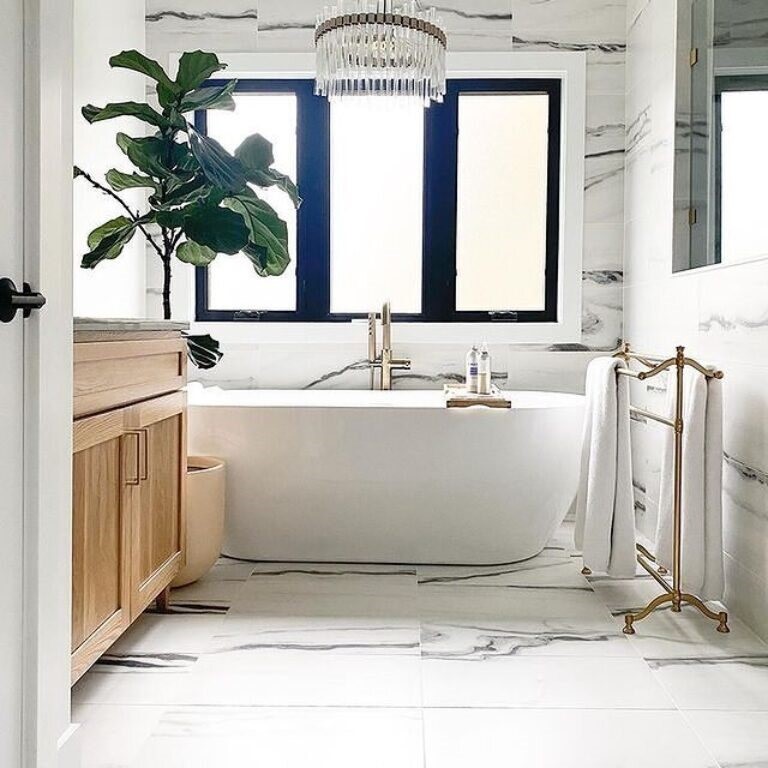 A bathroom with a white tub and a mirror