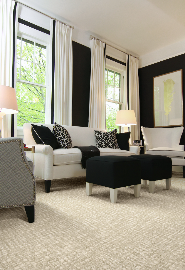 A living room with white couches and black chairs